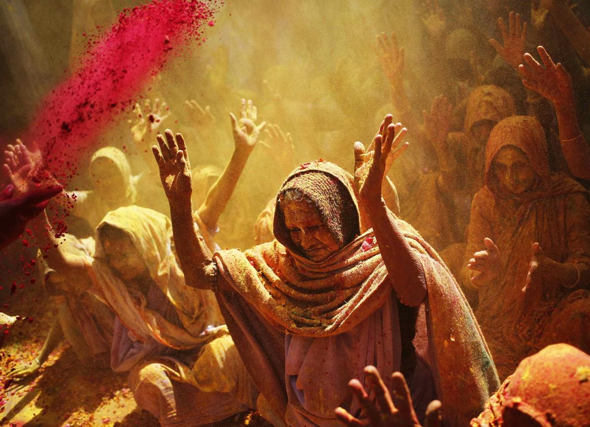Widows daubed in colors chanted religious hymns as they took part in the Holi celebrations on March 4. (Anindito Mukherjee/Reuters)