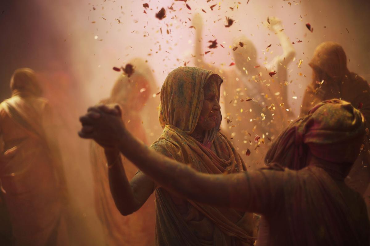 Widows daubed in colors danced at a widows' ashram at Vrindavan on March 6. (Adnan Abidi/Reuters)