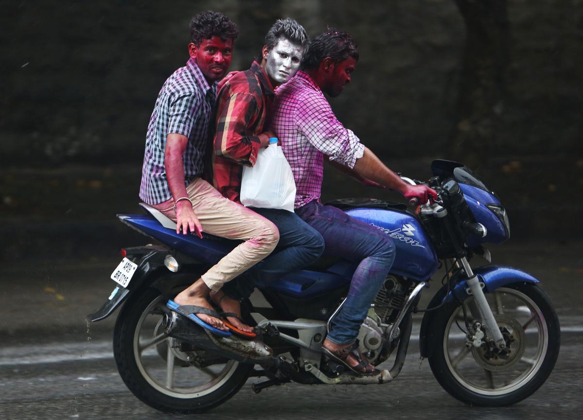 Indian men, their faces smeared with colored powder, rode a motorbike during Holi in Hyderabad, India, on March 6. (Mahesh Kumar A/Associated Press)