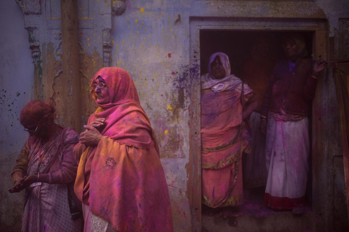 Indian Hindu widows stood covered with colored powder after celebrations marking Holi at the Pagal Baba Ashram in Vrindavan, India. (Tsering Topgyal/Associated Press)