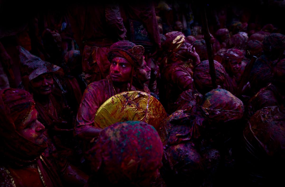 Indian Hindu devotees smeared with colors visited the Nandagram temple, famous for Lord Krishna and his brother Balram, during Lathmar Holi festival in Nandgaon, India, on Feb. 28. During Lathmar Holi the women of Nandgaon, the hometown of Krishna, beat the men from Barsana, the legendary hometown of Radha, consort of Hindu God Krishna, with wooden sticks in response to their teasing as they depart the town. (Saurabh Das/Associated Press)