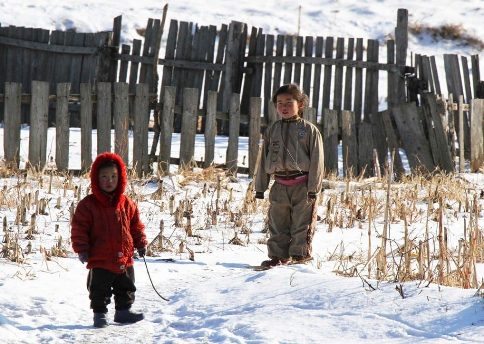 North Korean children stand after snowfall along the banks of the Yalu River, near the North Korean Sakchu County, December 17, 2014. Picture taken on the China side of the Yalu River. (Photo by Jacky Chen/Reuters)