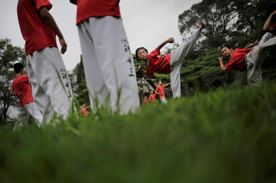 North Korean students practice Taekwondo at the Moranbong or Moran Hill in Pyongyang, North Korea, Thursday, July 31, 2014. Even in Pyongyang, people need a place to relax and unwind. With the heat and humidity of the Pyongyang summer now setting in, one of the most popular is Moranbong, Moran Hill, just a short walk from Pyongyang's iconic Kim Il Sung Square that is famous for its shady walking paths, vistas of the city and grassy fields. (Photo by Wong Maye-E/AP Photo)