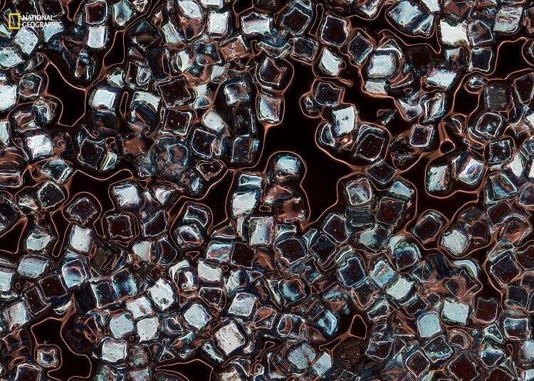 Eleanor Ryder/2016 National Geographic Nature Photographer of the Year. Toxic Vanity. 3rd Place—Environmental Issues:This image is a magnification of plastic particles in eyeliner, exploring just one facet of the synthetic swarm suspended in our oceans. The particles, lash-lengthening fibers, illuminating powders, and glitters these products contain are in fact tiny pieces of plastic. Every time we wash these products from our bodies or ingest them as we lick the glosses from our lips, we unknowingly add to the trillions of microplastic particles currently infesting every level of the ocean. This photograph was taken at Falmouth University in Cornwall, United Kingdom, in May 2016 using a reflective photographic microscope with a stacking panoramic process to create the final image.