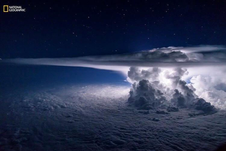 Santiago Borja/2016 National Geographic Nature Photographer of the Year. Pacific Storm. 3rd Place—Landscape: An isolated cumulonimbus storm developed over the Pacific Ocean a few miles south of the coast of Panama City. It sat atop a temperature inversion that created a thick overcast layer of clouds. The strong updrafts of the storm quickly reached the tropopause and spread out, creating the characteristic anvil. The strongest updrafts pierced the tropopause and turned into what scientists call the overshooting tops. The entire frame was lit by a single lightning from within the storm in a moonless night on June 16, 2016.