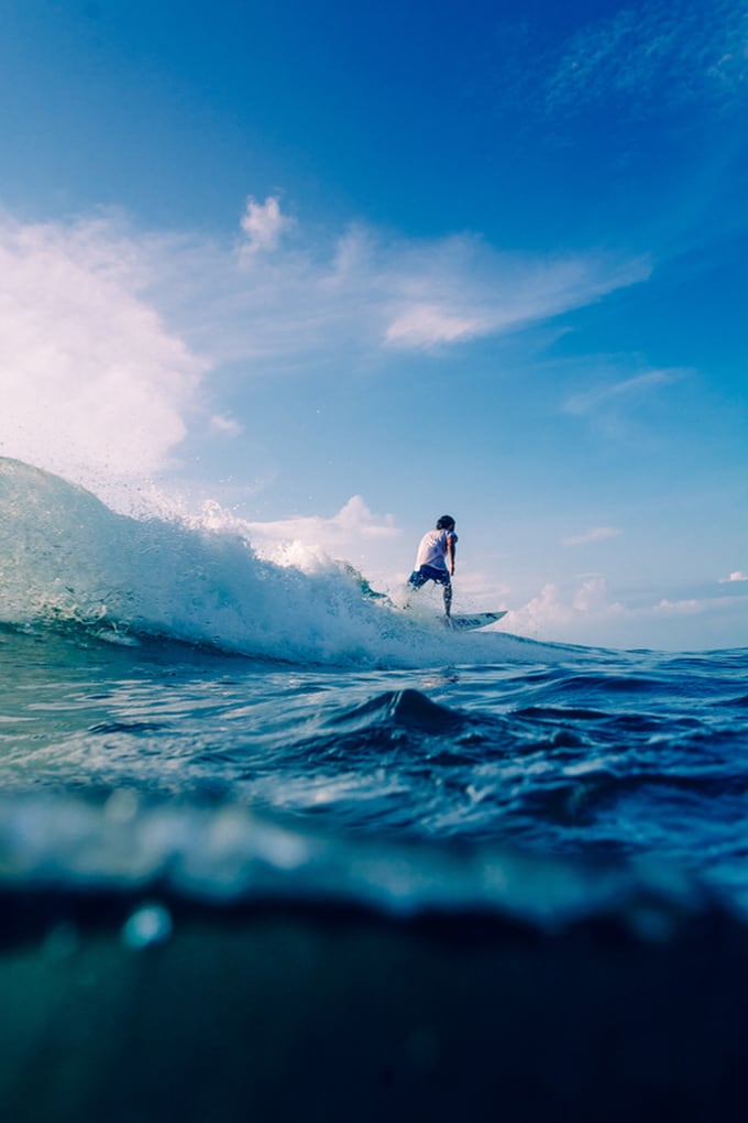 Surfer riding a wave in Uluwatu, Bali