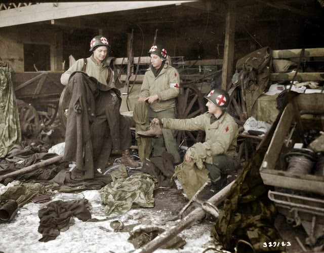 Medics of the US. 5th Infantry Division examining GI clothing found with German-captured equipment after the liberation of the area, near Diekirch in Luxembourg on the 20th of January 1945. (Source - SC-327129 Signal Corps Photo ETO-HQ-45-9223 -Horton. Colorized by Joey Van Meesen from the Netherlands)