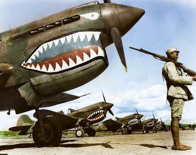 A Chinese Nationalist soldier guards a row of Curtiss P-40 'Warhawks' flown by the 'Flying Tigers' of the American Volunteer Group (AVG). July, 1942. (Source - National Archives and Records Administration - 535531. Colorized by Tom Thounaojam from India)