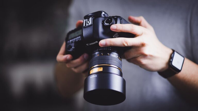 person holding canon dslr camera