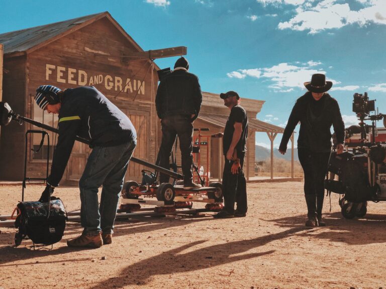 four men standing outside feed and grain store